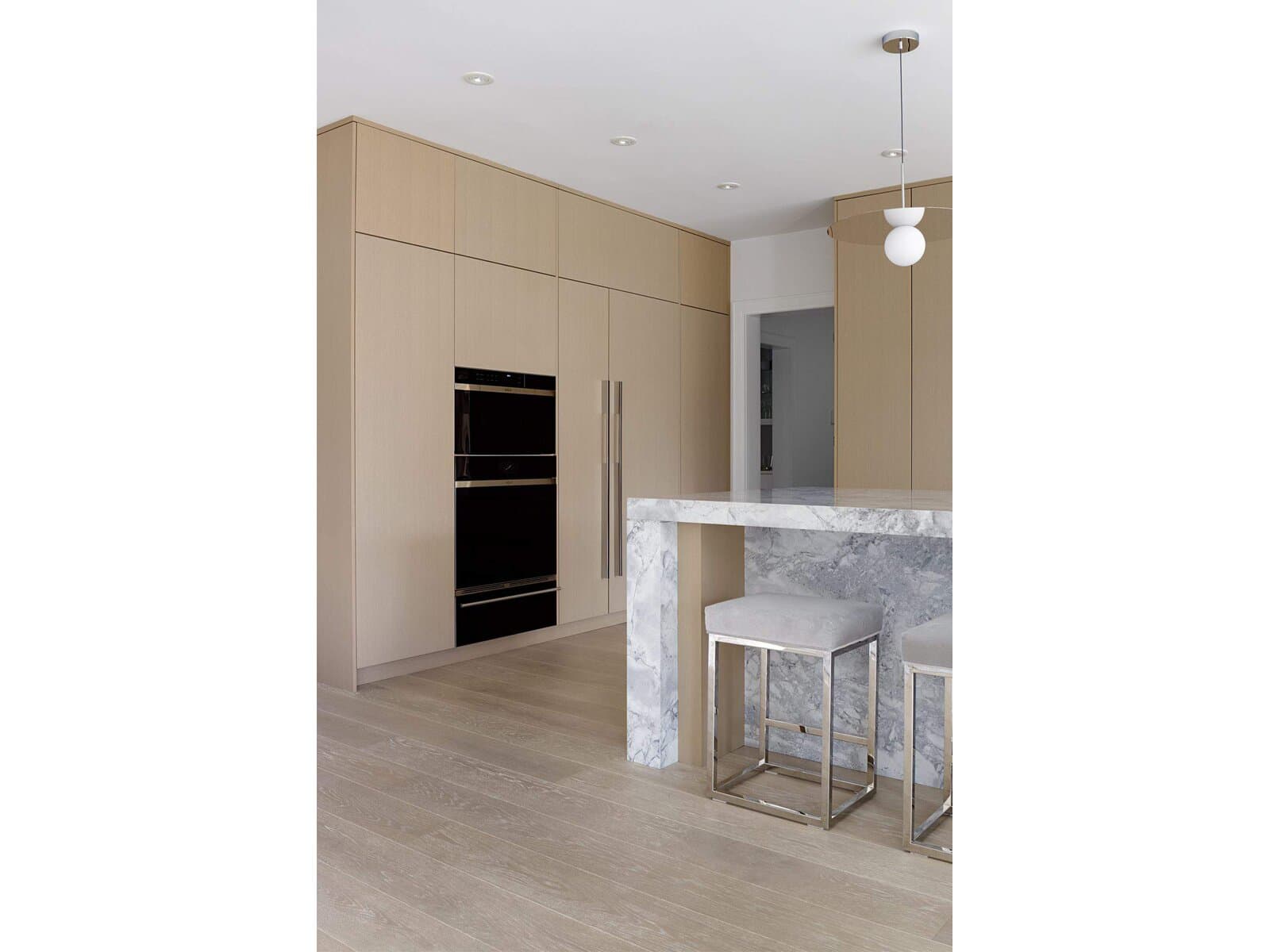Modern kitchen in rift oak slab cabinetry with a waterfall island