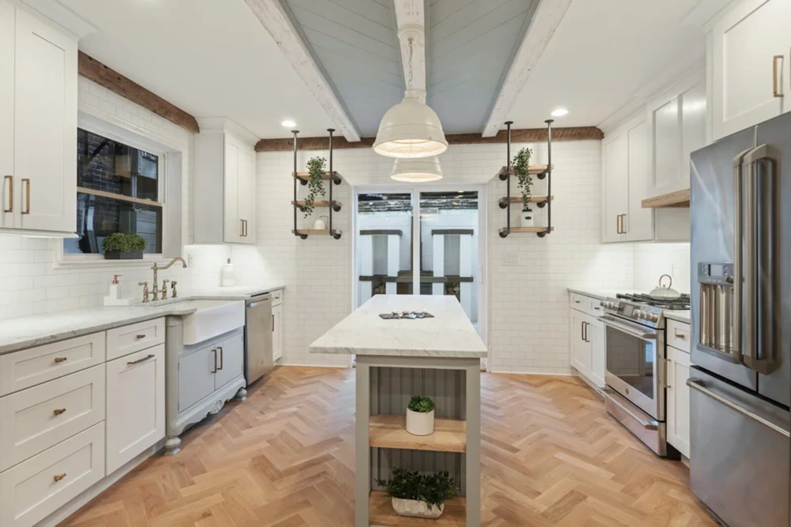 White Shaker kitchen with a large island and brass hardware