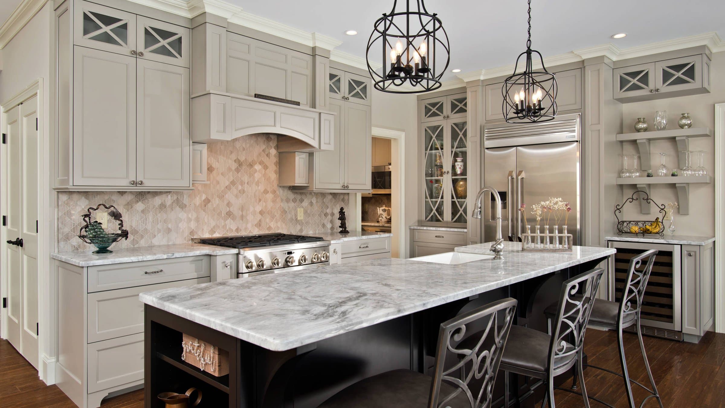 A warm, custom kitchen with painted Shaker cabinetry, a large island and brass hardware